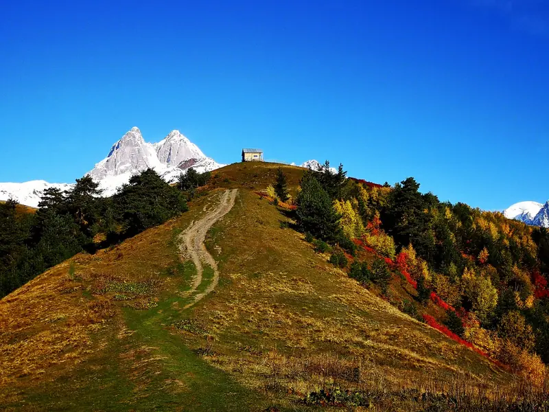 Track to a hilltop hut with the twin peaks of Ushba behind